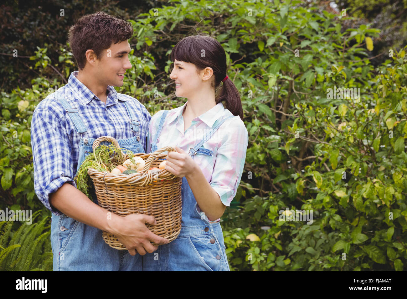 Young couple holding un panier de légumes fraîchement récoltés Banque D'Images