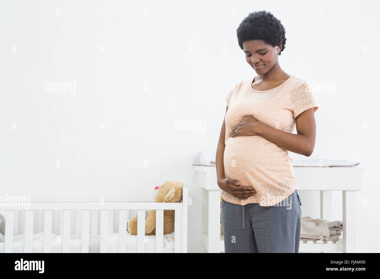 Femme enceinte, debout près de l'arceau et regardant son ventre Banque D'Images