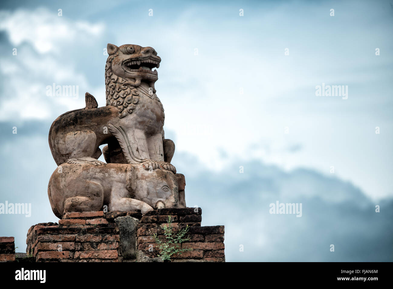 Statue du lion gardien du temple d'Abeyadana Bagan Myanmar // BAGAN, Myanmar — Une statue de lion gardien restaurée placée au sommet d'un éléphant orne le toit du temple d'Abeyadana (également connu sous le nom APE-Ya-da-na ou APE-Yadana-Phaya). Le temple date de la fin du XIe siècle ou du début du XIIe siècle et est situé près du temple Nagayon, juste au sud du village de Myinkaba dans la zone archéologique de Bagan. Le temple Abeyadana se distingue parmi les temples de l'ère païenne pour son imagerie bouddhiste Mahayana dans ses fresques, contrastant avec les thèmes Theravada plus communément trouvés dans d'autres temples de l'époque. Le temple présente SLO Banque D'Images
