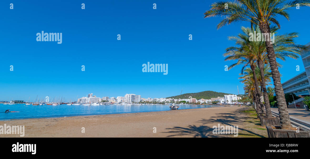 Les palettes de l'homme son voile d'administration en St Antoni de Portmany, Ibiza, au bord de l'eau en vue d'un voilier échoué et abandonné sur la plage. Banque D'Images