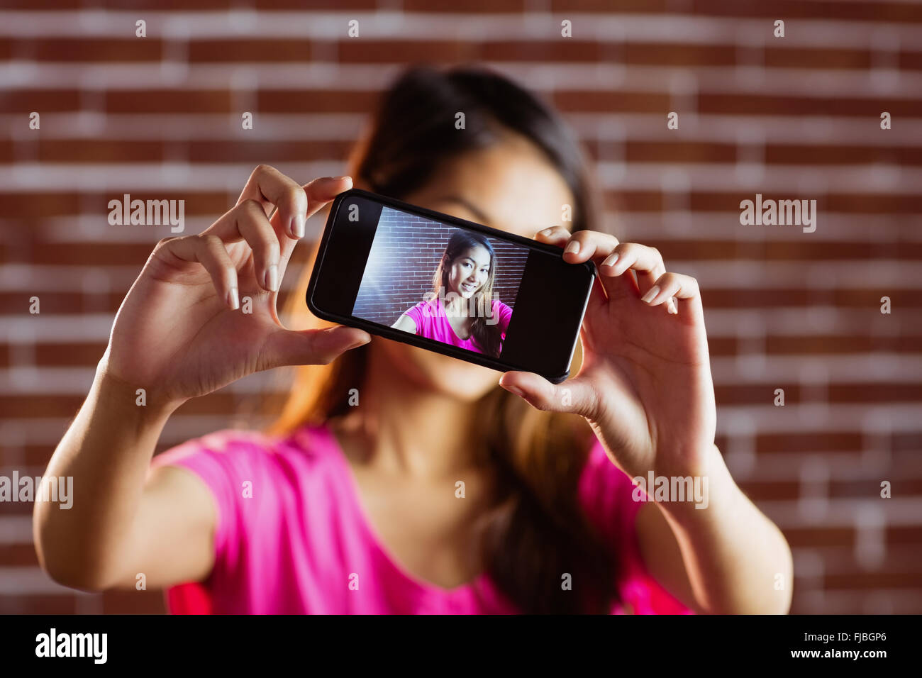 Smiling asian woman with smartphone selfies Banque D'Images
