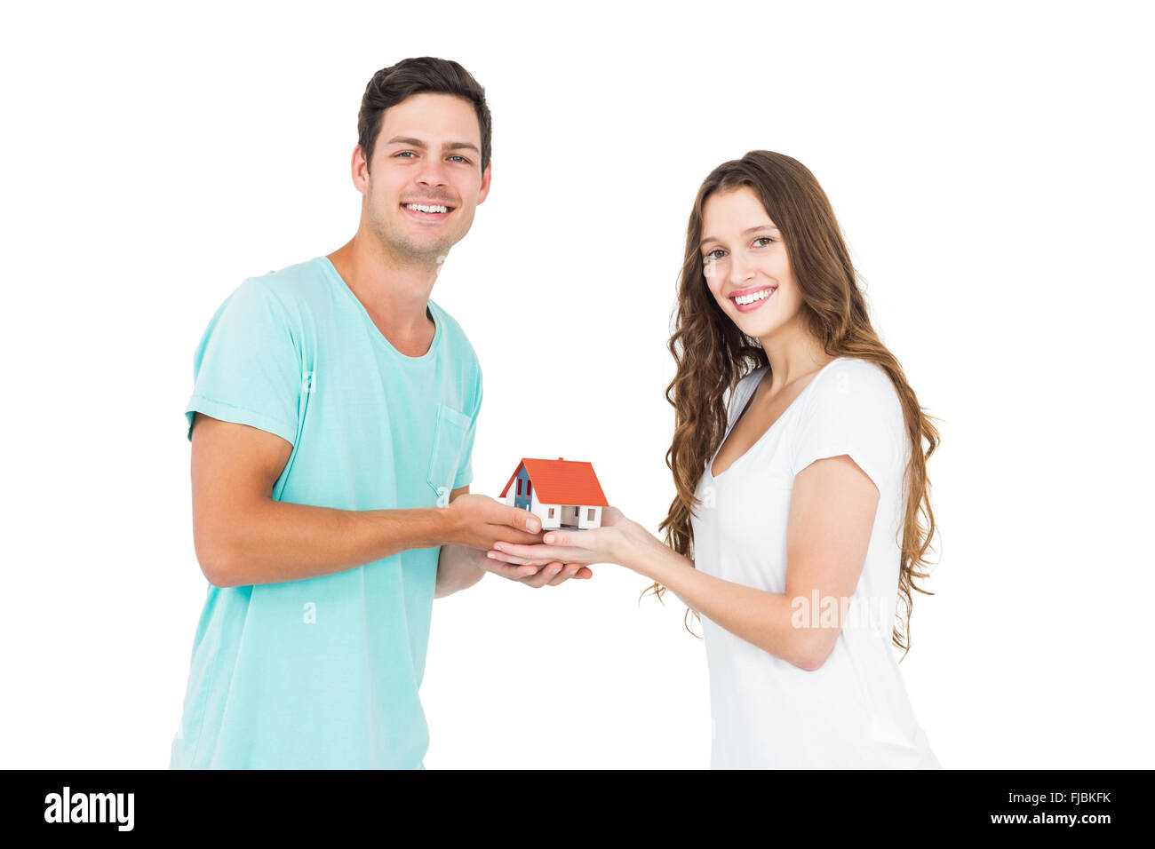 Heureux couple holding miniature house Banque D'Images