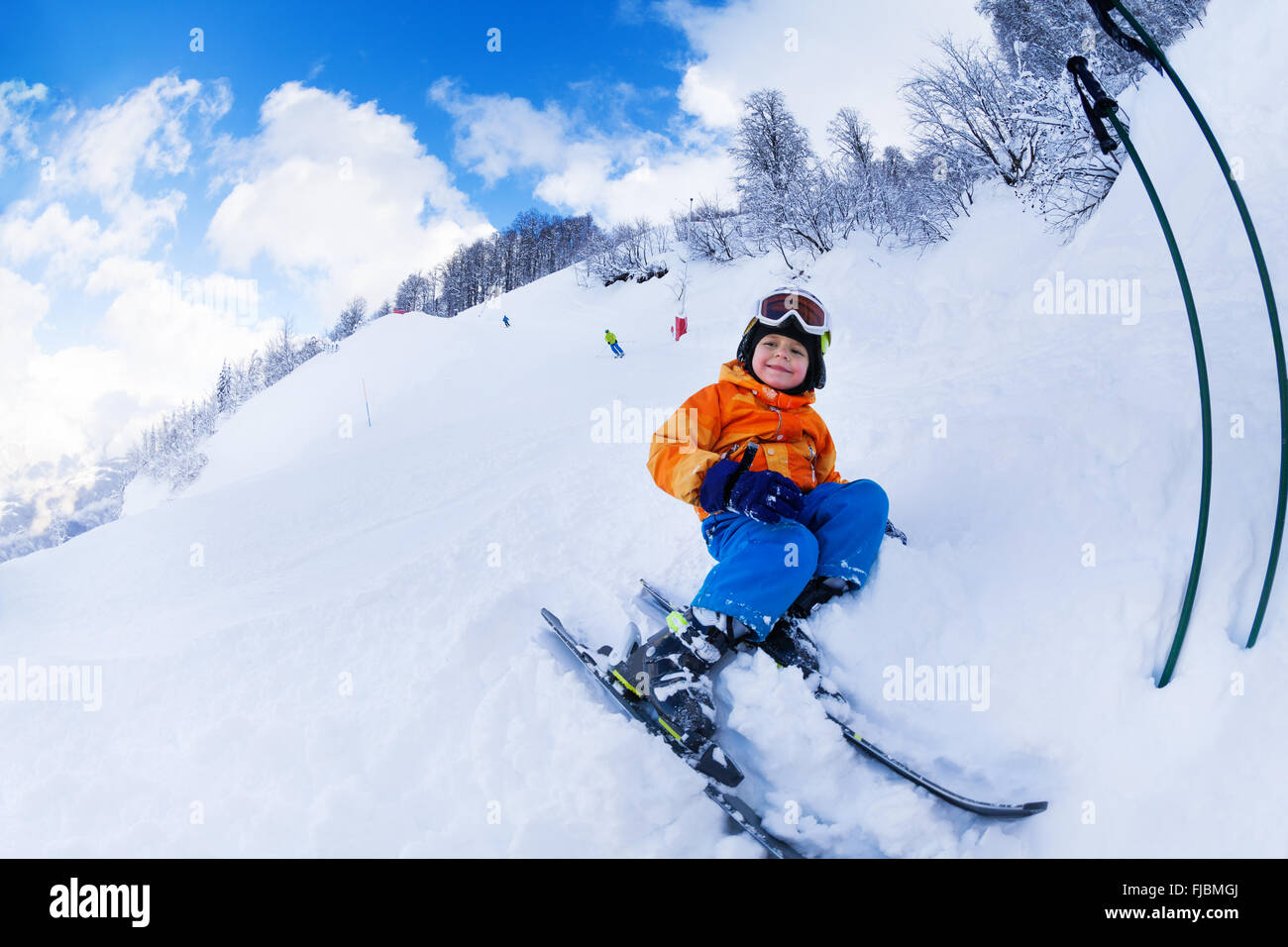 Petit garçon skieur assis avec repos dans la neige ski Banque D'Images