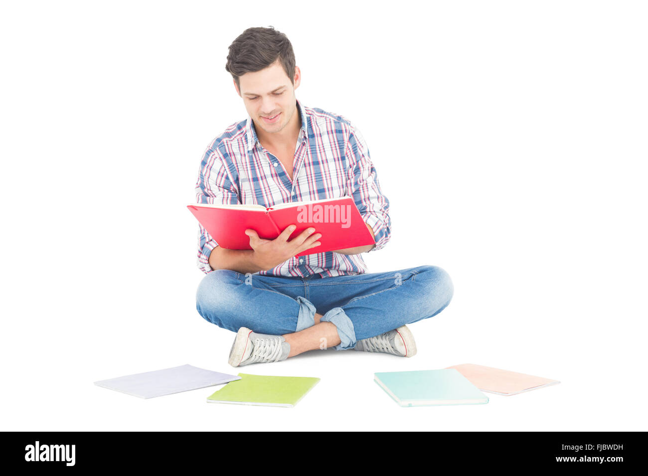 Homme lisant un livre tout en restant assis sur le sol Banque D'Images