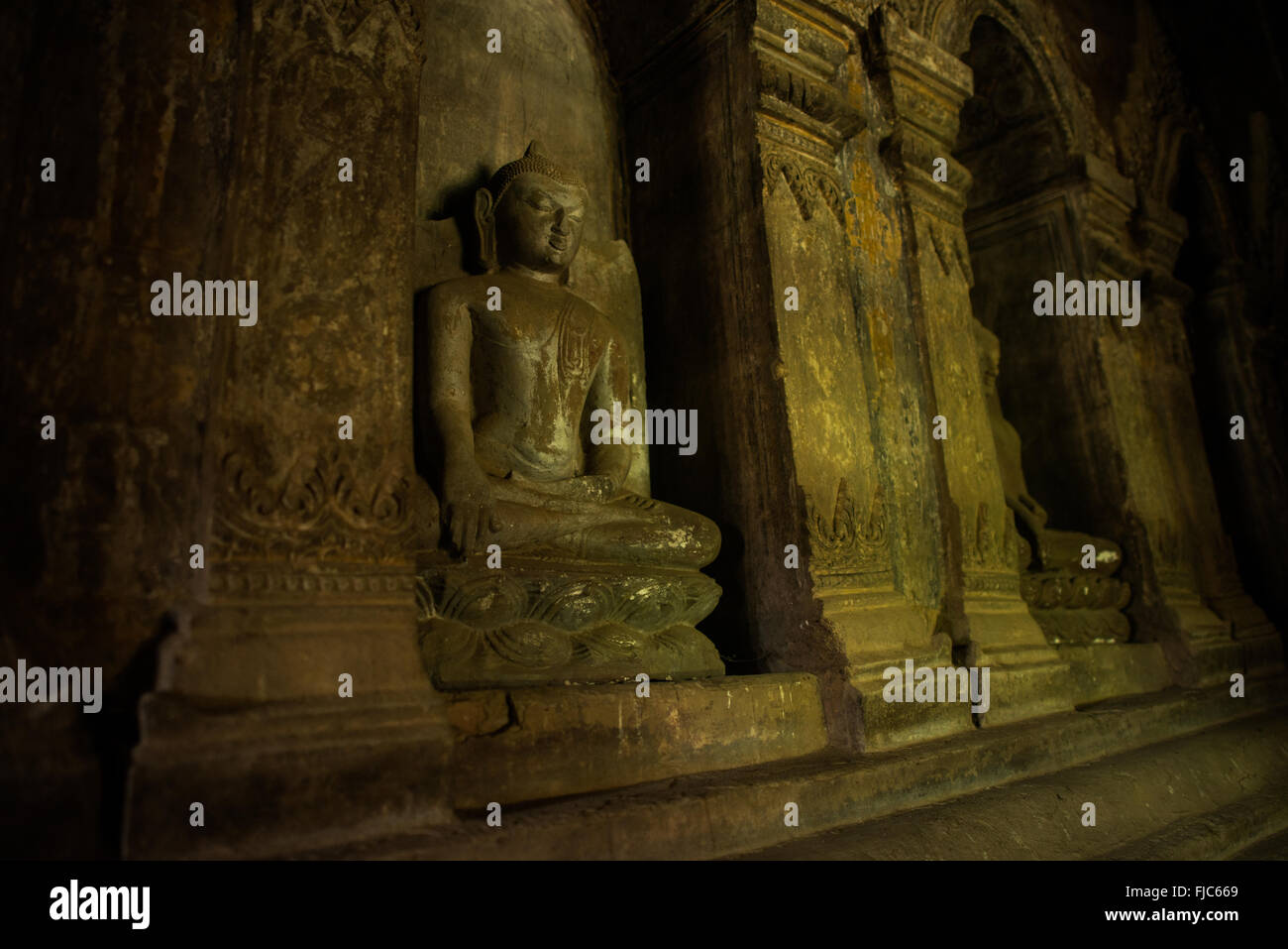 Temple d'Abeyadana statues de Bouddha Bagan Myanmar // BAGAN, Myanmar — Une rangée d'alcôves contenant des statues de Bouddha et des restes de fresques murales à l'intérieur du temple d'Abeyadana (également connu sous le nom de temple d'Apeyadana) dans la zone archéologique de Bagan. Le temple du XIe au XIIe siècle est remarquable pour son imagerie bouddhiste Mahayana dans ses fresques, qui contraste avec les thèmes Theravada couramment trouvés dans d'autres temples du début de Bagan. Le nom du temple dérive de la reine Abeyadana, une reine consort en chef du XIe siècle du roi Kyansittha de la dynastie païenne, bien qu'aucune preuve solide ne confirme le lien légendaire avec le te Banque D'Images