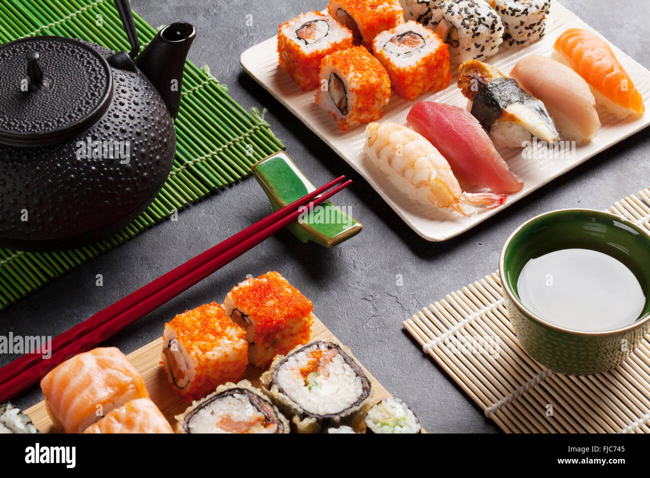 Ensemble de sushi et maki roll et thé vert sur table en pierre Banque D'Images