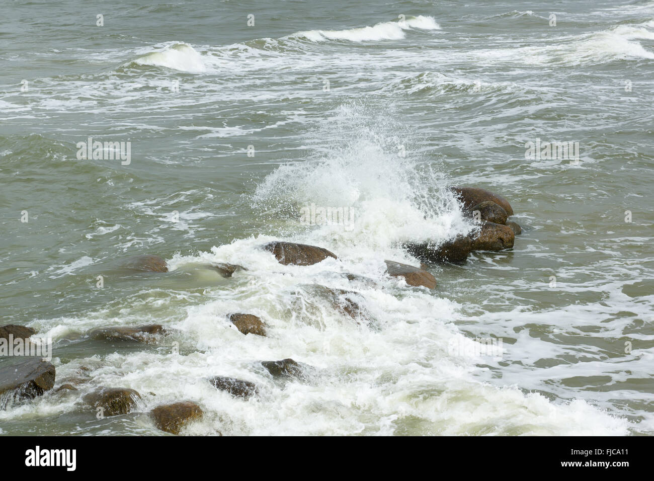 Des pierres se trouvent dans une mer déchaînée sous les coups de grosses vagues Banque D'Images