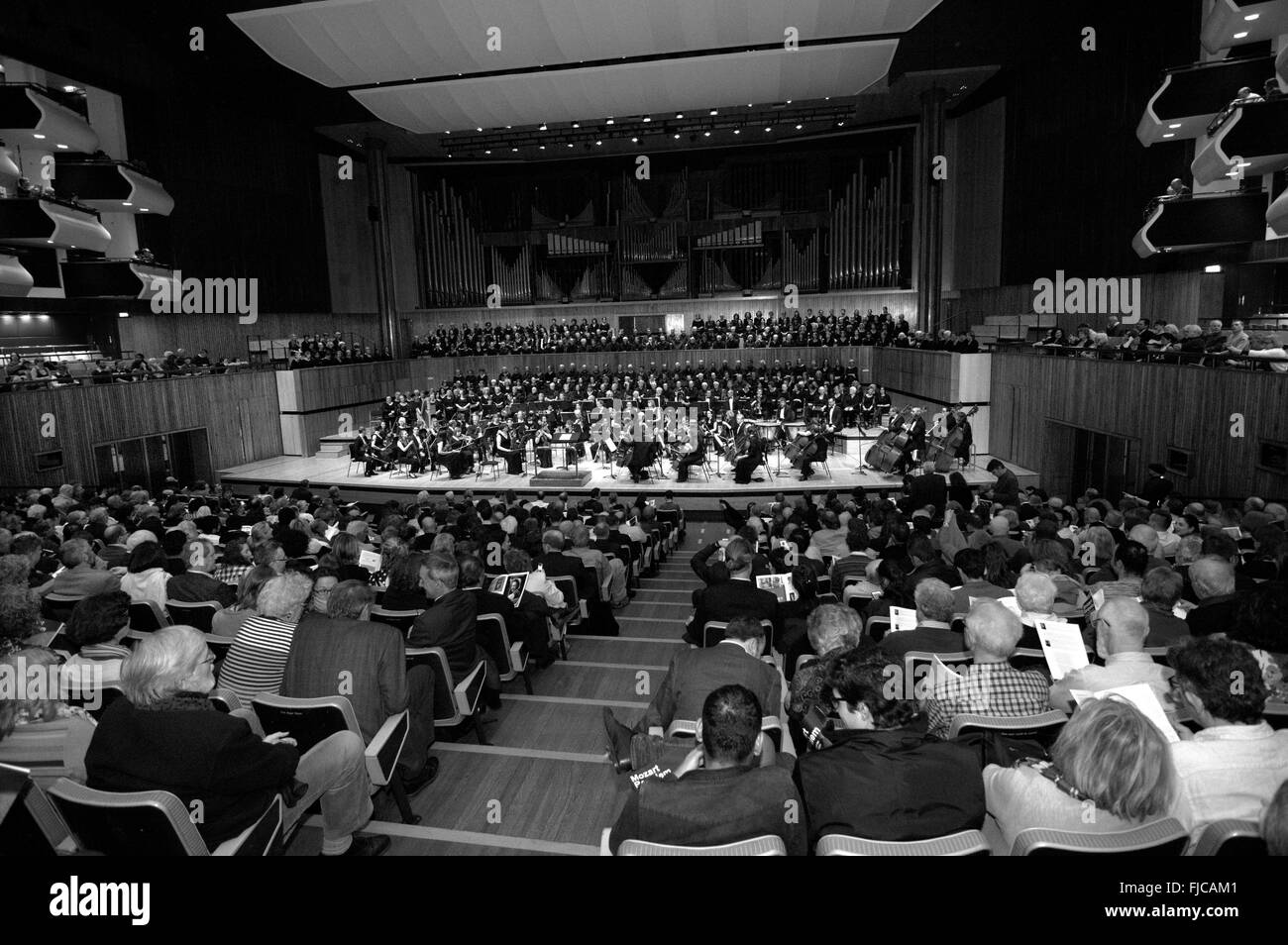 Image en noir et blanc de choeur et orchestre dans le Southbank Royal Festival Hall avec un auditoire plein la vue et des balcons Banque D'Images