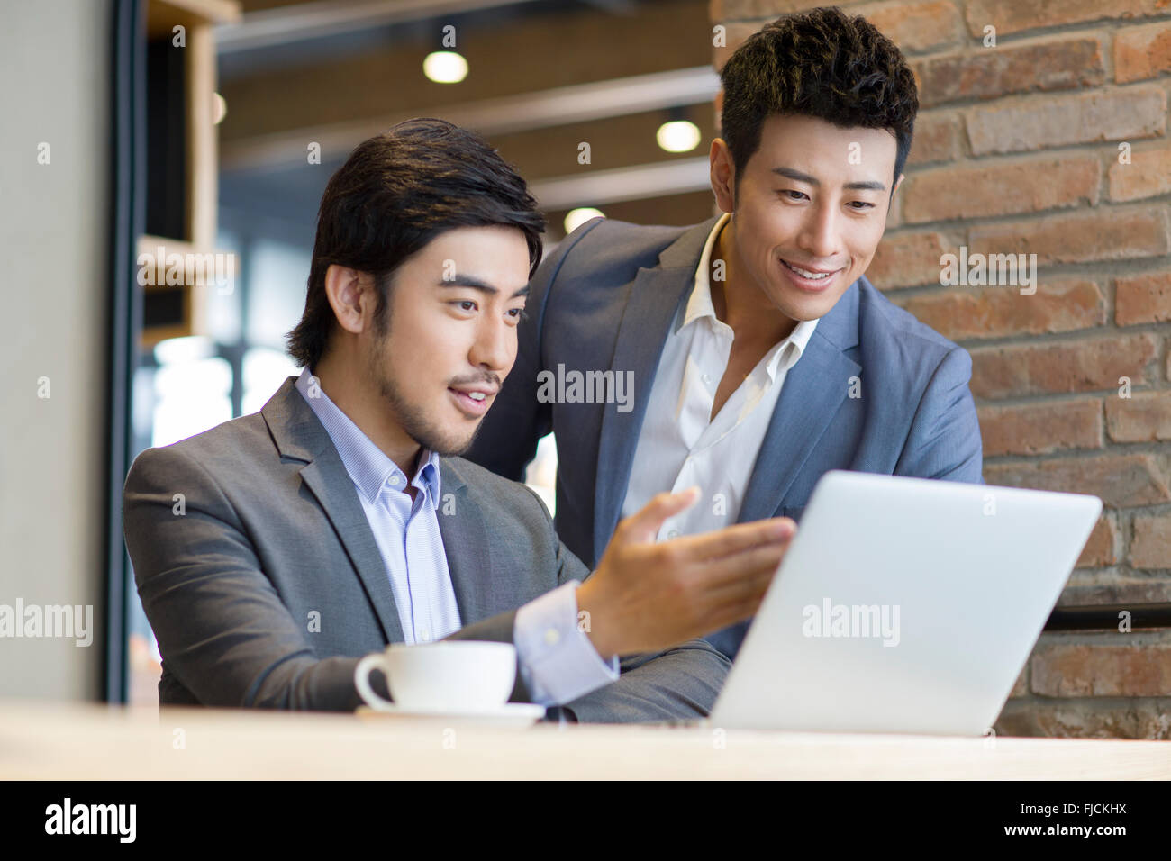 D'affaires chinois travaillant avec un ordinateur portable dans un café Banque D'Images