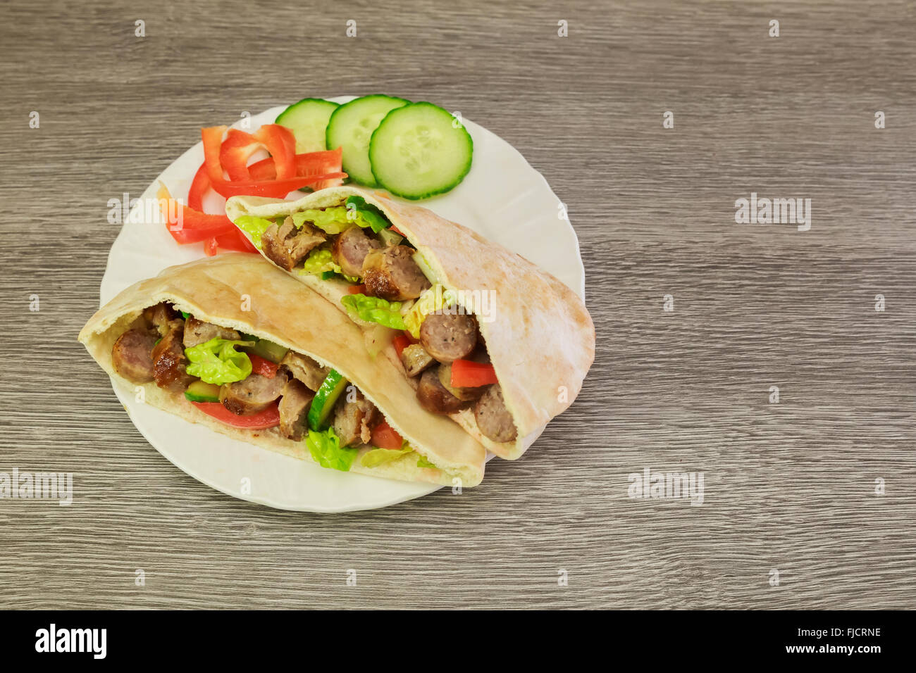 Falafels et légumes frais au pain de pita sur sol en bois Banque D'Images