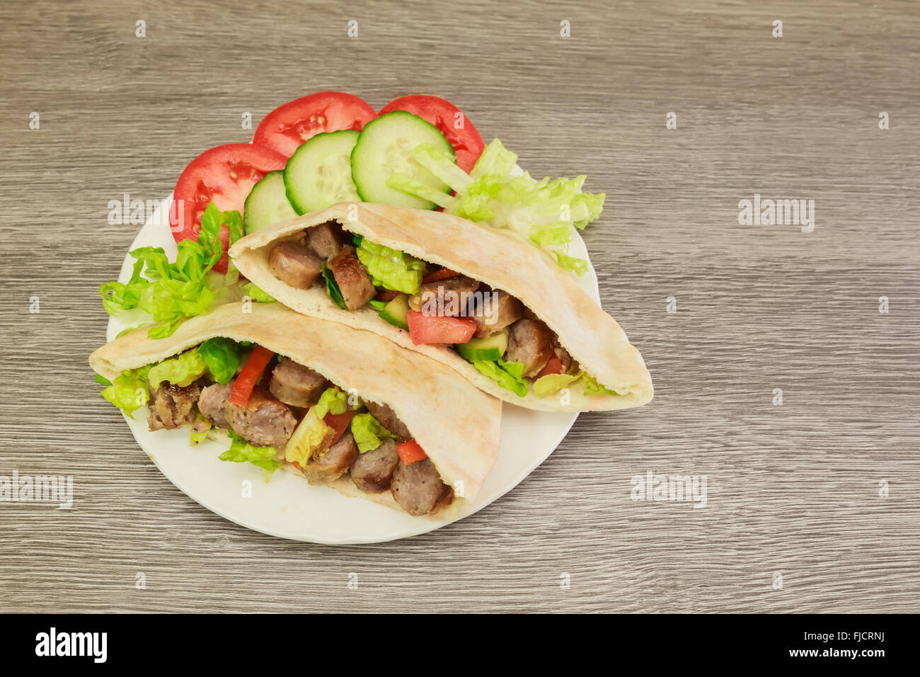 Falafels et légumes frais au pain de pita sur sol en bois Banque D'Images