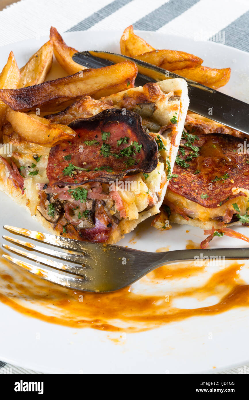 Les vestiges d'une plaque de pizza et frites/frites les restes de la veille. Banque D'Images
