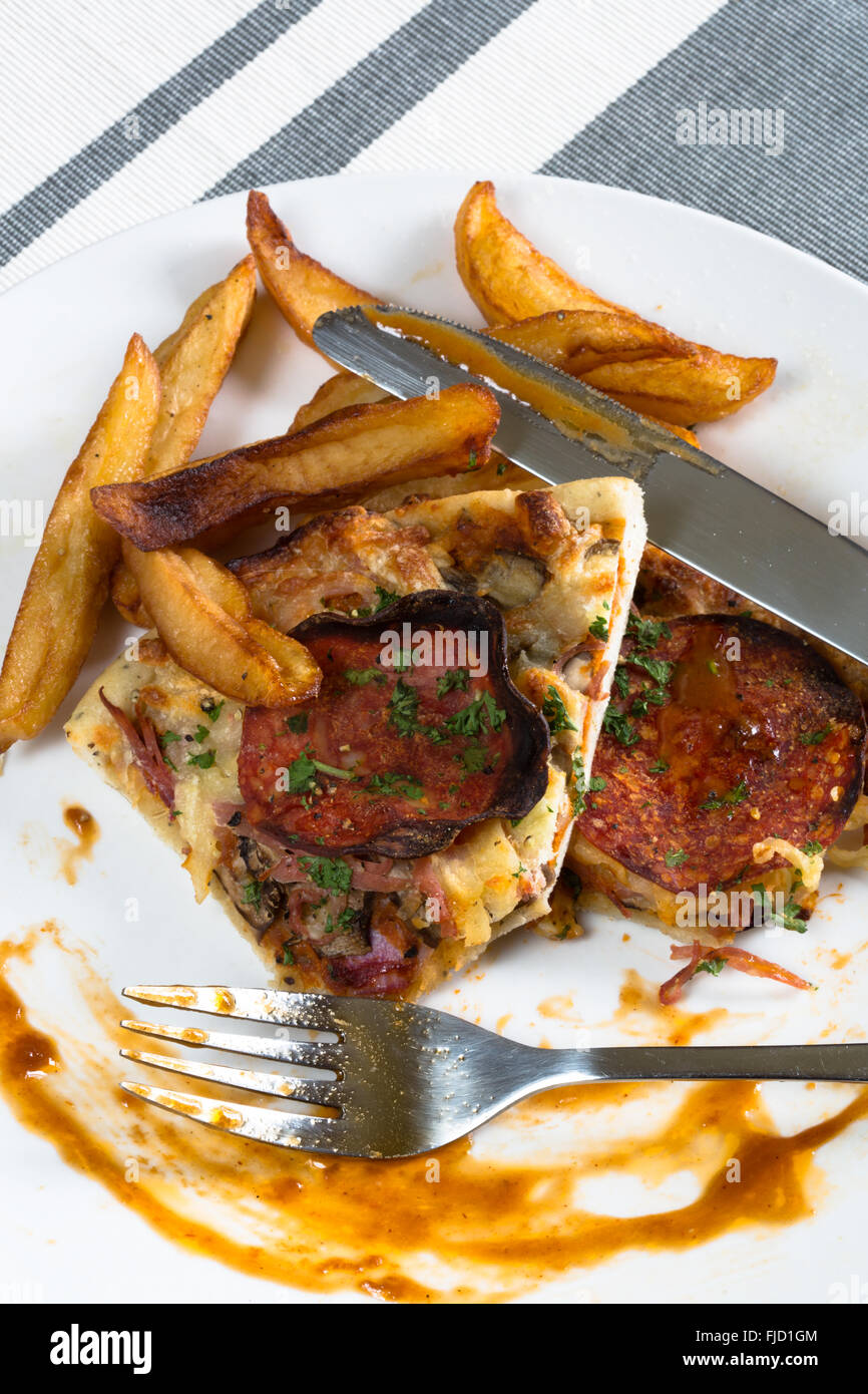 Les vestiges d'une plaque de pizza et frites/frites les restes de la veille. Banque D'Images