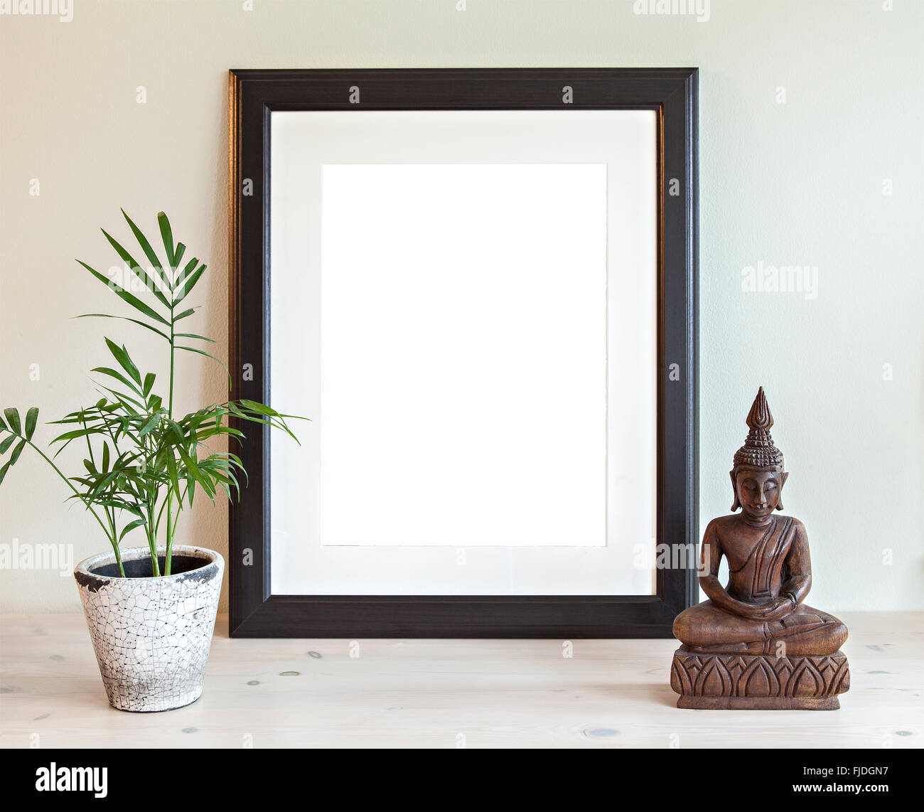 Image d'une maquette de scène avec cadre en bois, plante et statue de Bouddha. Banque D'Images