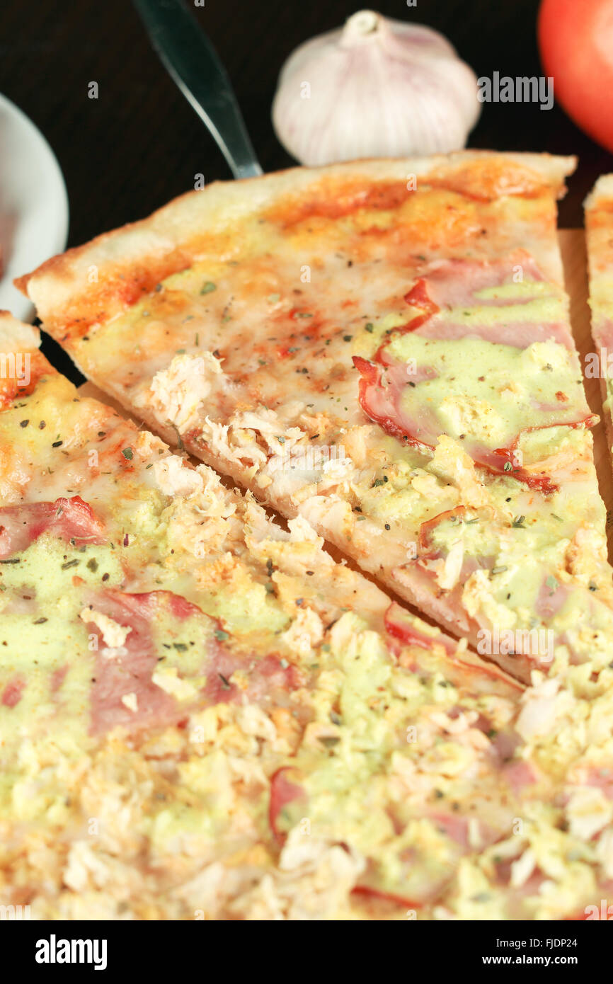 Belle italienne pizza au jambon et au poulet close-up vertical. Profondeur de champ Banque D'Images