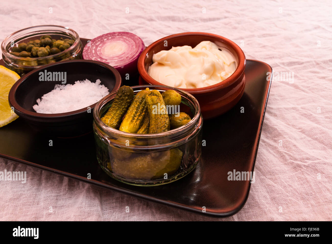 Le bac avec des ingrédients pour faire la sauce tartare, mayonnaise, sel, cornichons, câpres, oignons et citron Banque D'Images