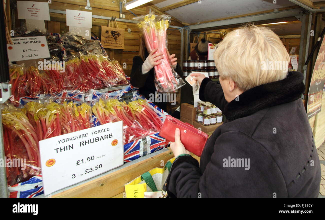 Un client achète la rhubarbe Yorkshire forcé découle d'une échoppe de marché à la rhubarbe du festival dans le centre de Wakefield, Royaume-Uni Banque D'Images