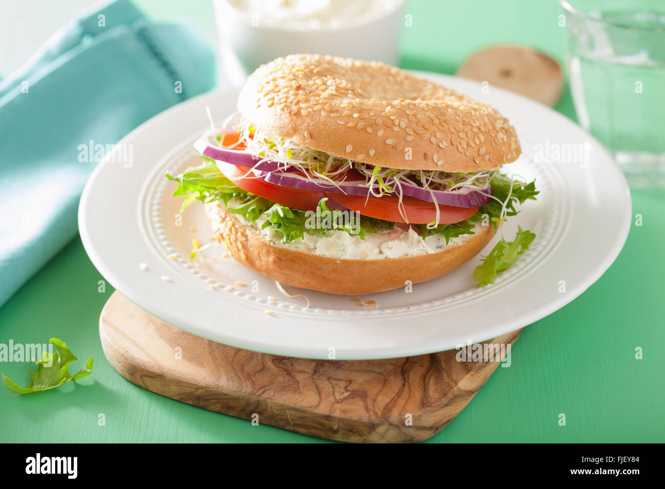 Le sandwich tomate bagel avec fromage à la crème de laitue oignon luzerne Banque D'Images