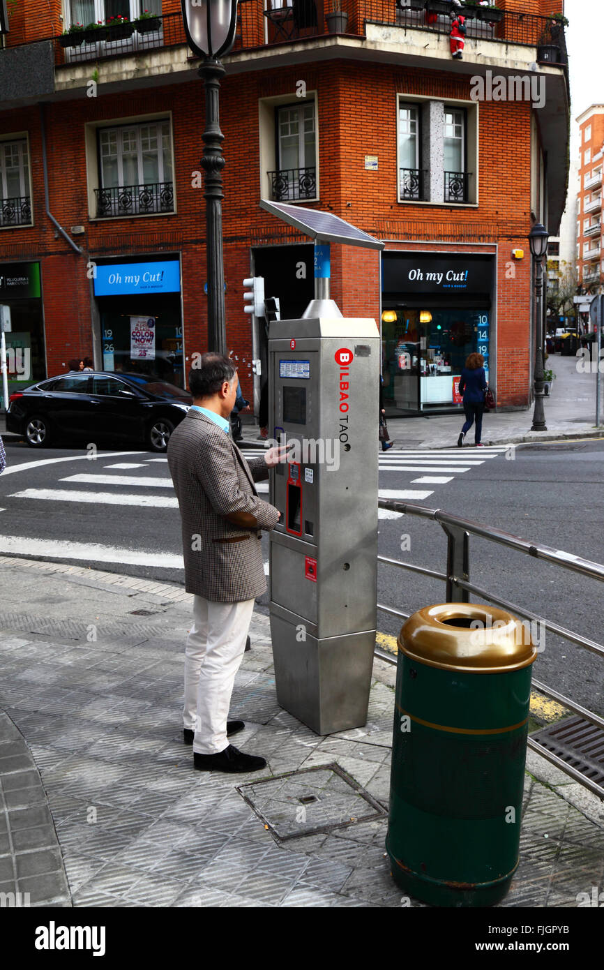 Homme achetant un billet en utilisant un parcmètre solaire qui fait partie du système de stationnement public OTA-TAO, centre de Bilbao, pays Basque, Espagne Banque D'Images