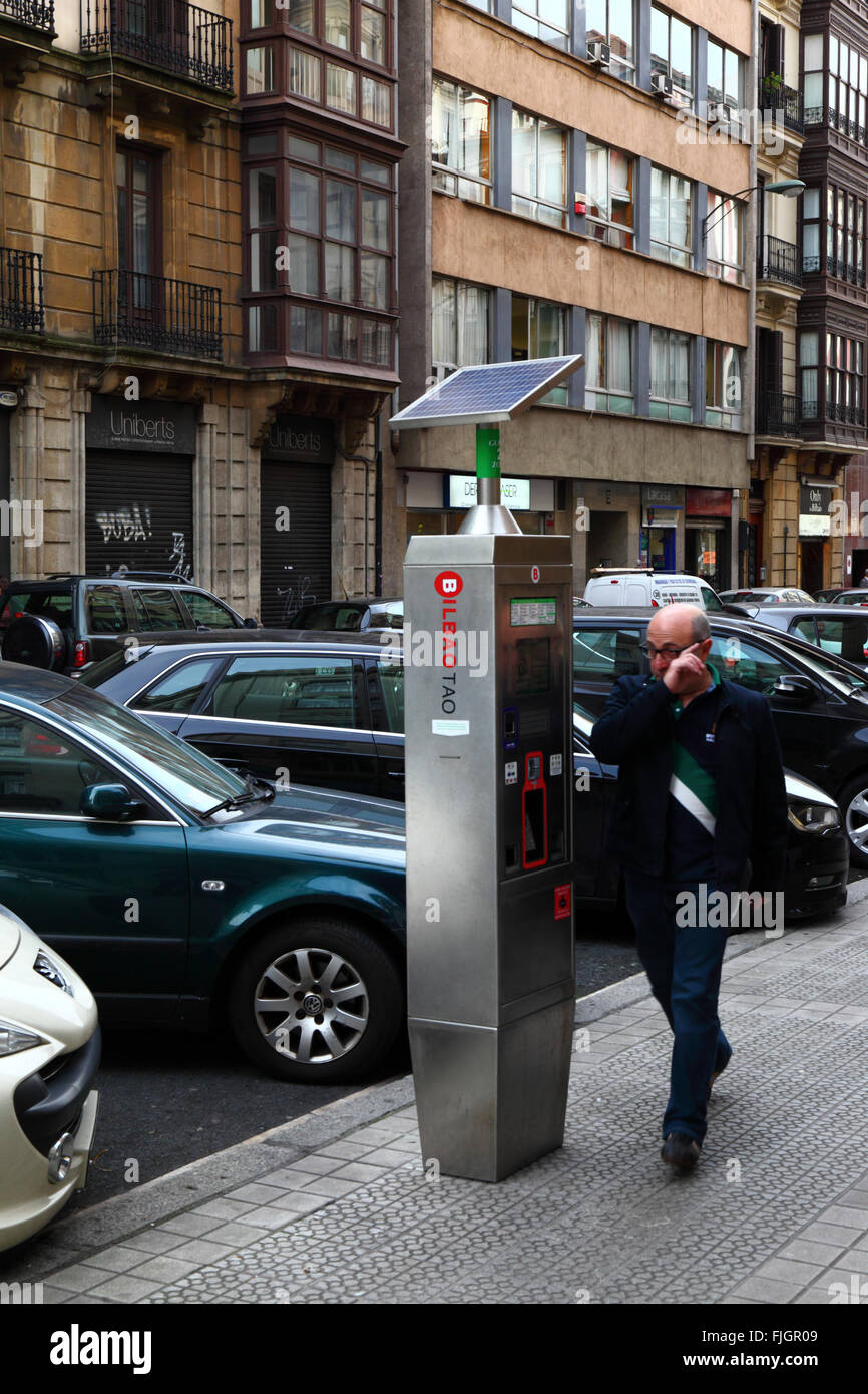 Homme marchant devant un parcmètre solaire qui fait partie du système de stationnement public OTA-TAO, centre de Bilbao, pays Basque, Espagne Banque D'Images