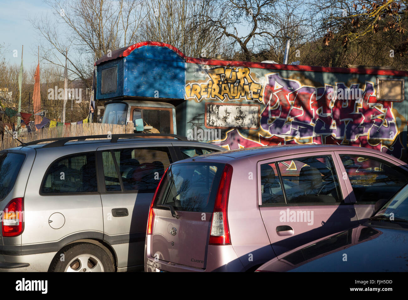 Slogan "Graffiti pour l'espace libre à une remorque dans un autre établissement (Wagenburg) avec des voitures parking en face Banque D'Images