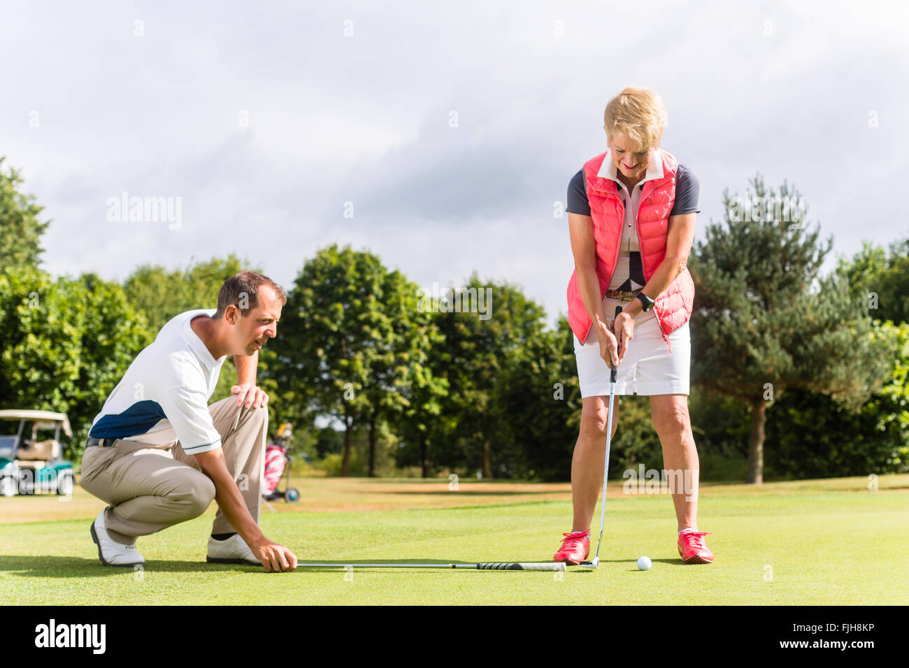 Femme Senior pro de golf et pratiquer leur sport Banque D'Images