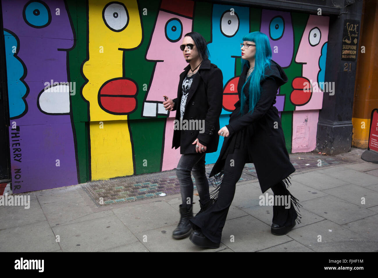 Cyber Goths en dehors d'un shop peint avec des visages cartoon sur Denmark Street à Londres, au Royaume-Uni. Cybergoth est une sous-culture qui dérive d'éléments de goth, raver, et rivethead mode. A l'inverse des Goths, Cybergoths suivez la musique électronique plus souvent que rock. Banque D'Images