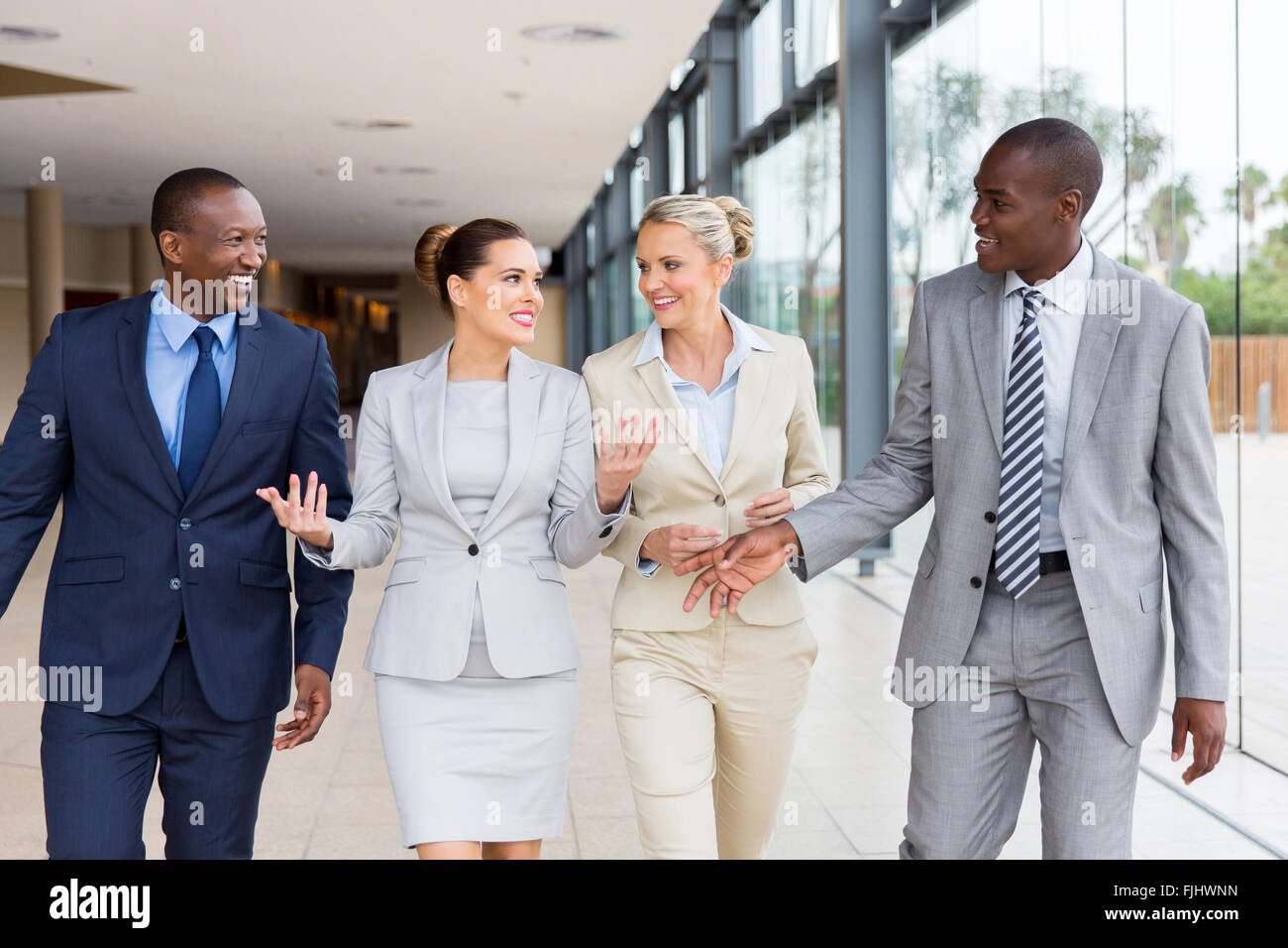 Belle société multiraciale businesspeople walking together in office building Banque D'Images