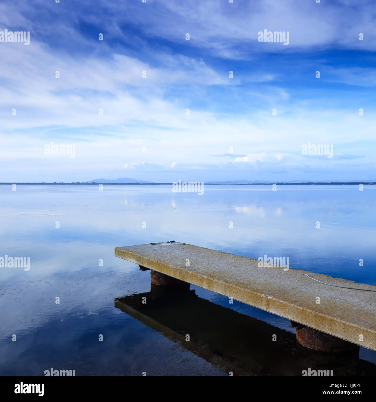 Jetée en béton ou jetty et sur un lac bleu et ciel nuageux la réflexion sur l'eau. Banque D'Images