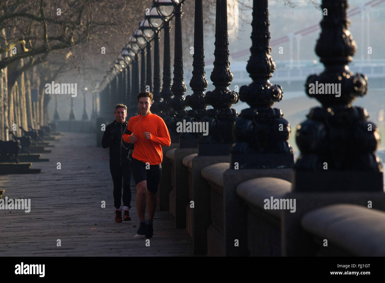 Londres, 24 février 2016. Glissières de la Tamise à côté de jog sur Cheyne à pied comme le soleil se lève sur un matin froid mais claire Banque D'Images