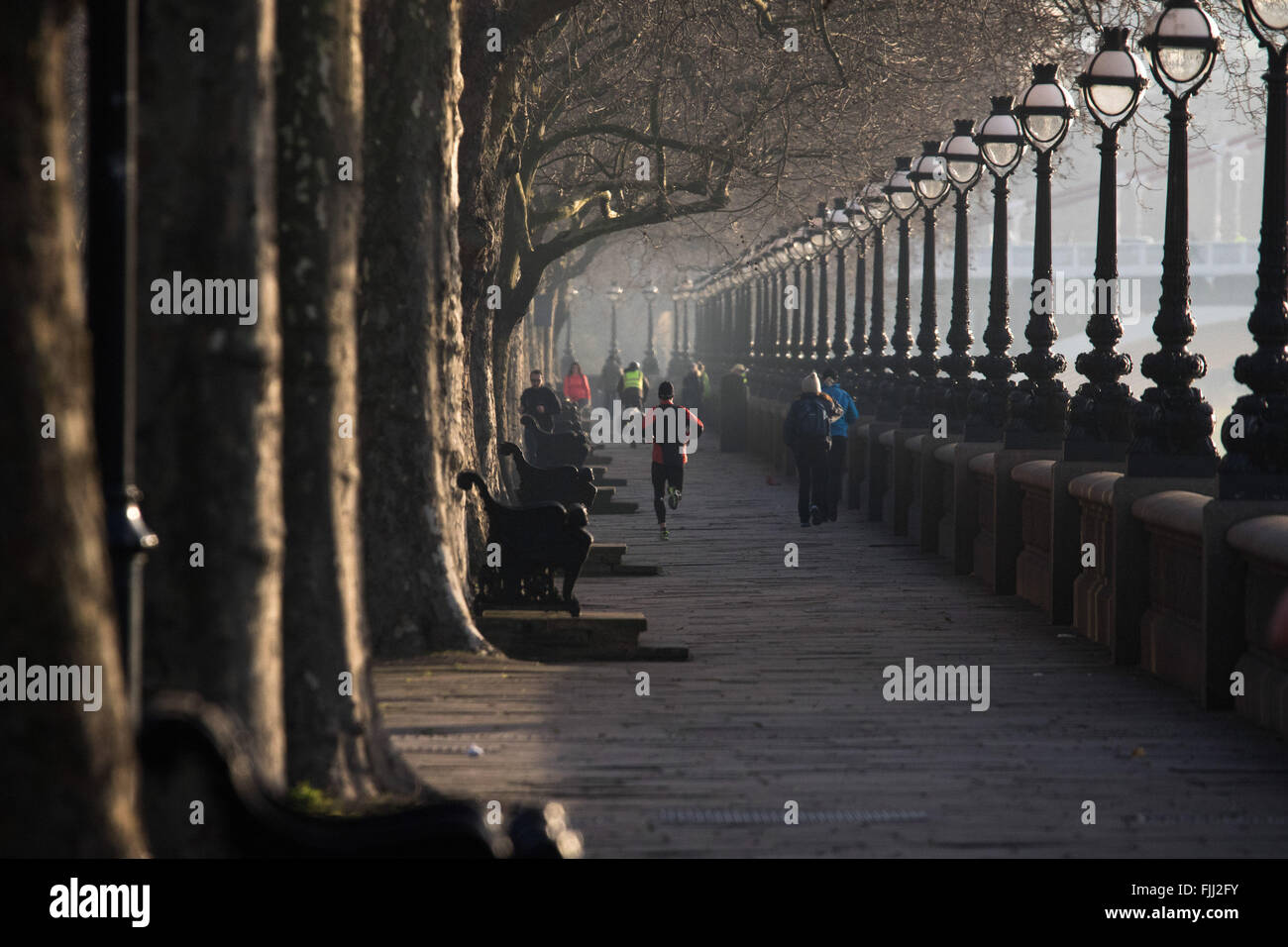 Un runner jogging le long de la Tamise à Cheyne à pied comme le soleil se lève sur un matin froid mais claire Londres. Banque D'Images