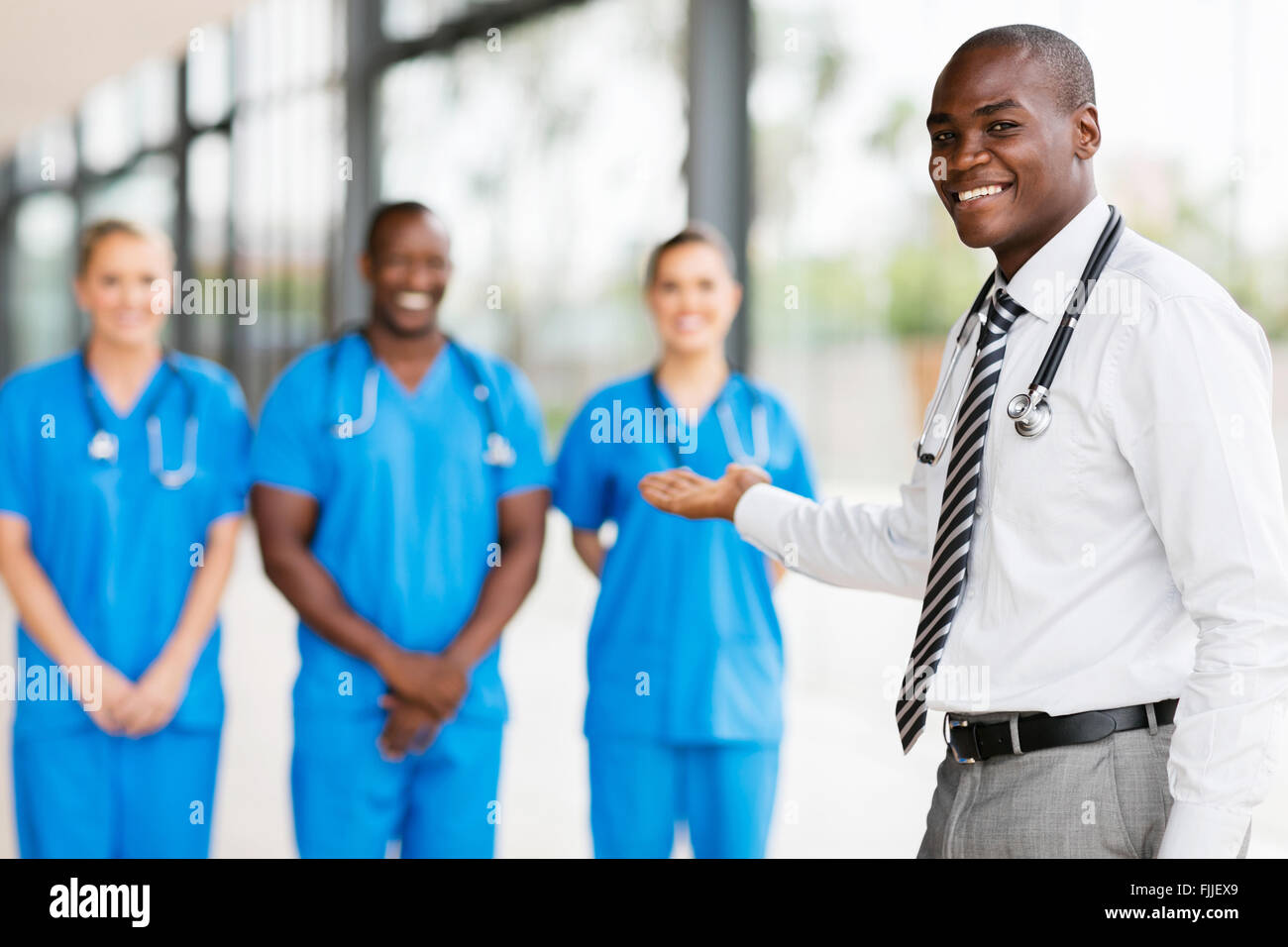 Happy African doctor presenting medical team Banque D'Images