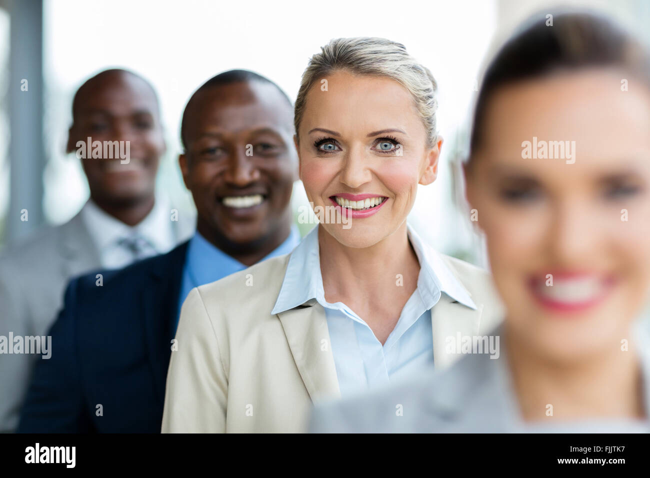 Happy mid age businesswoman standing in a row avec l'équipe d'entreprise Banque D'Images
