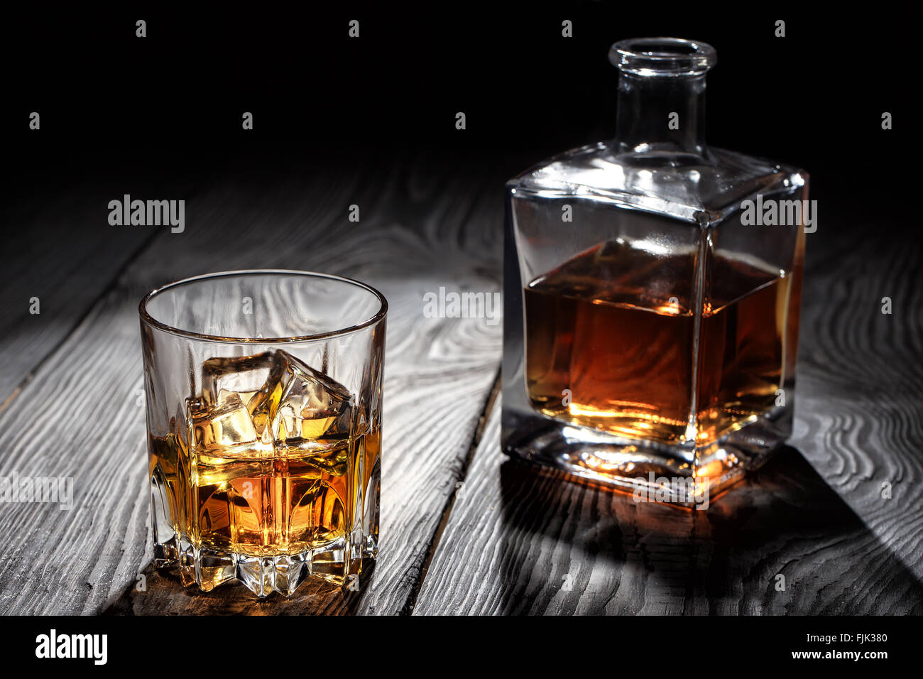 Éclairé par led verre de whisky avec de la glace sur une table en bois Banque D'Images