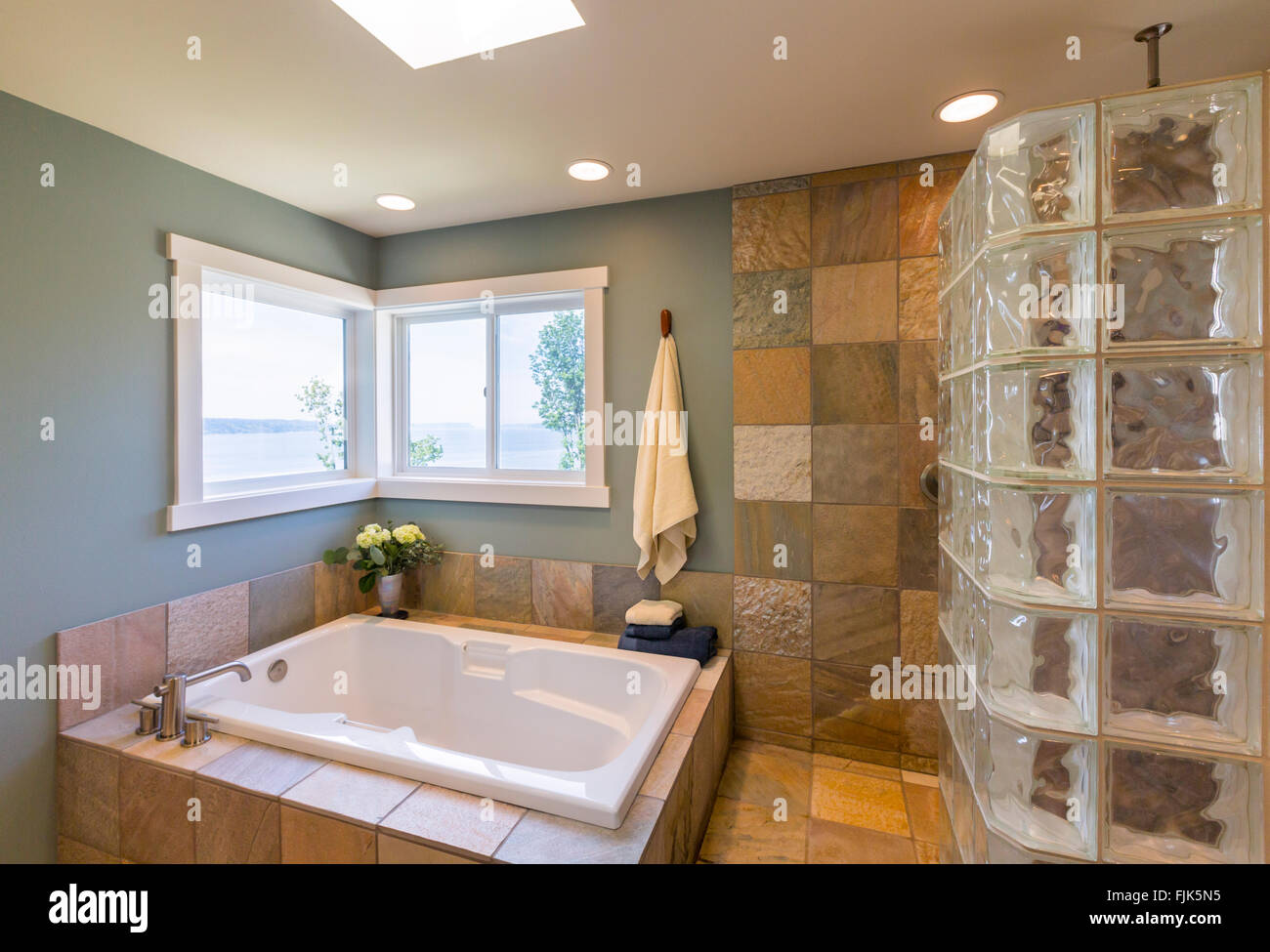 Haut de gamme contemporain Accueil Salle de bains spa intérieur avec des carreaux en verre de douche, murs recouverts de carreaux en ardoise, acrylique baignoire et vue windows Banque D'Images