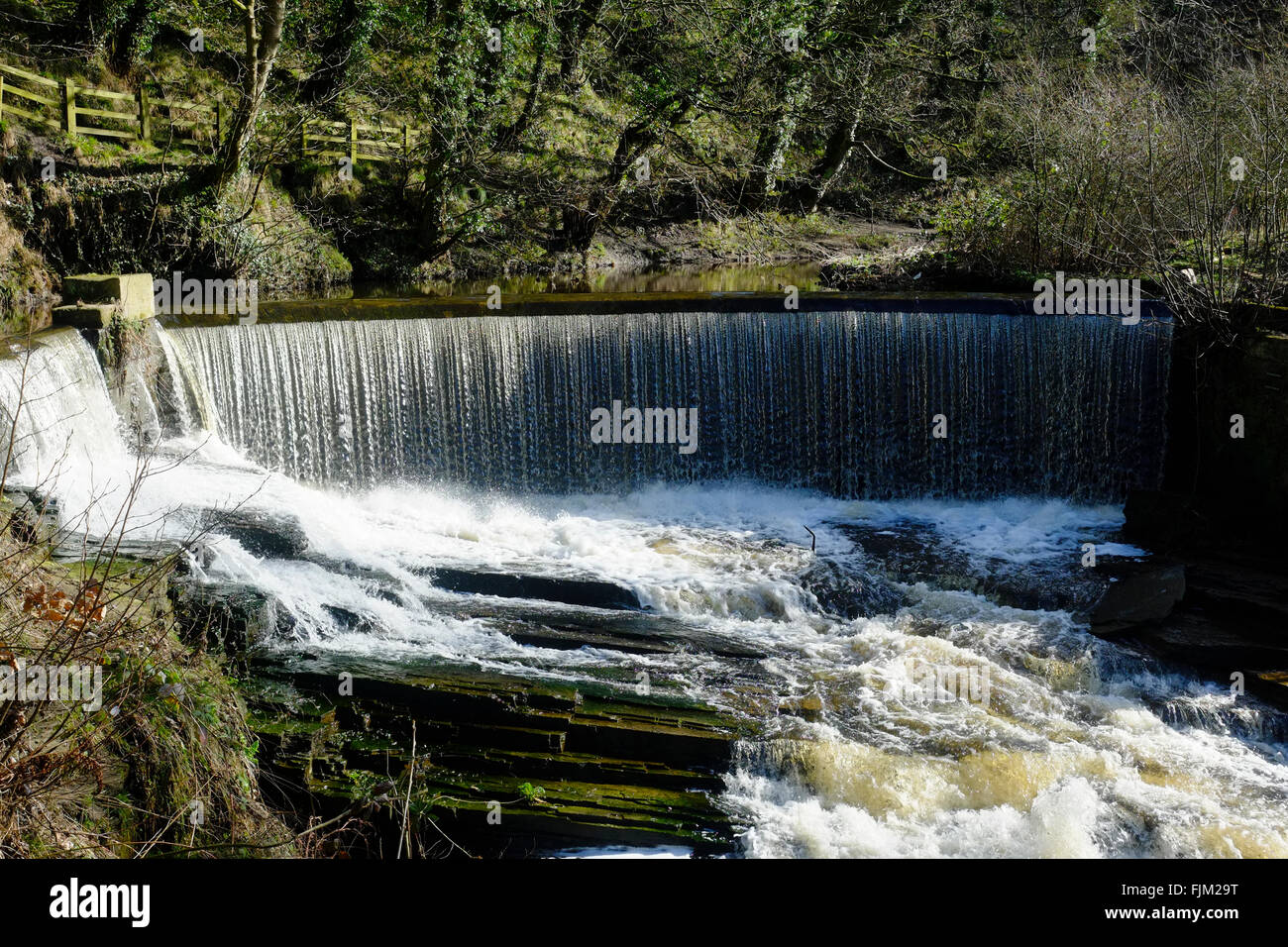 La rivière en crue avec Weir Banque D'Images