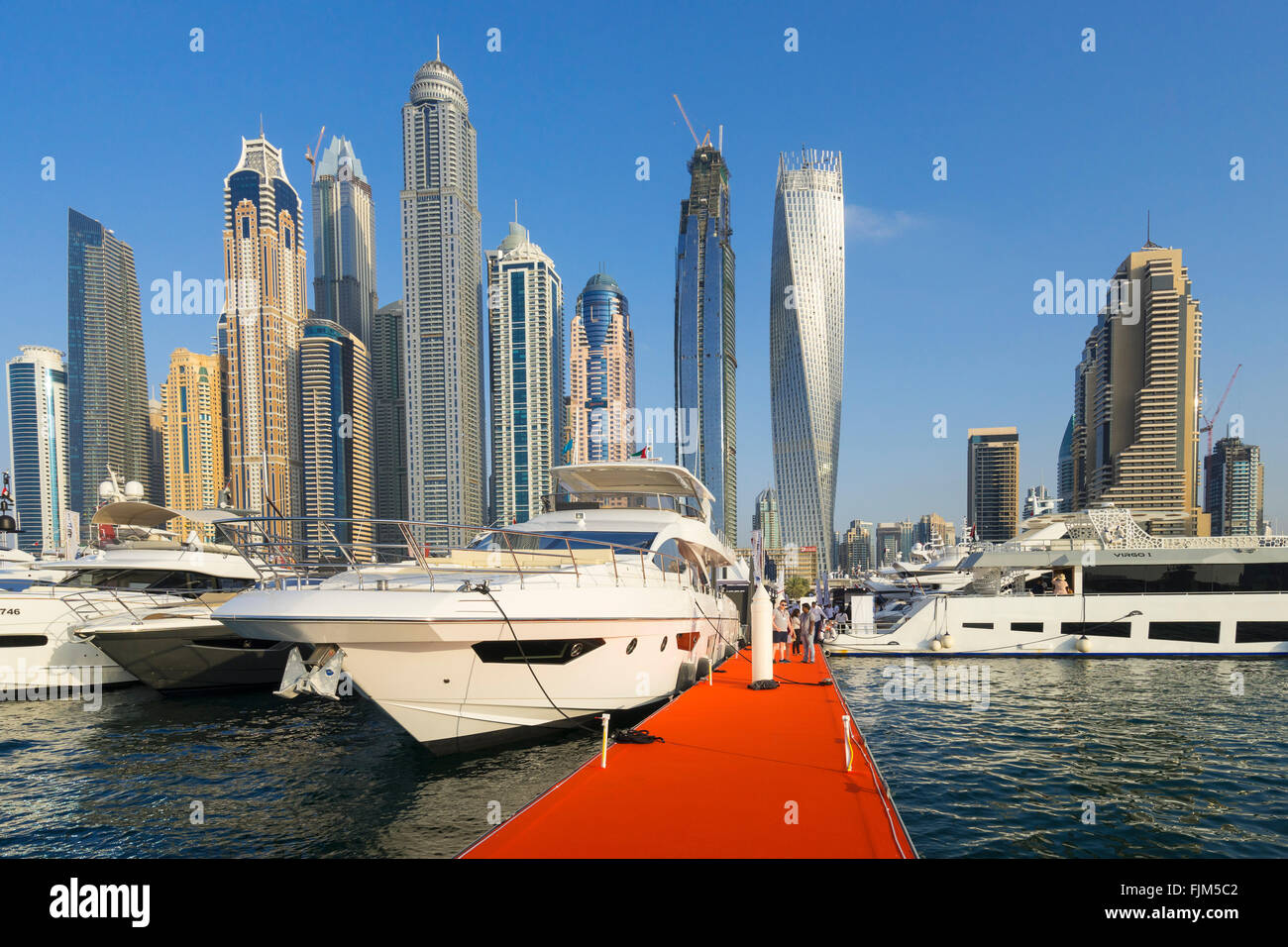 Megayachts à moteur sur l'affichage avec des toits de gratte-ciel au Dubai International Boat Show 2016 Banque D'Images