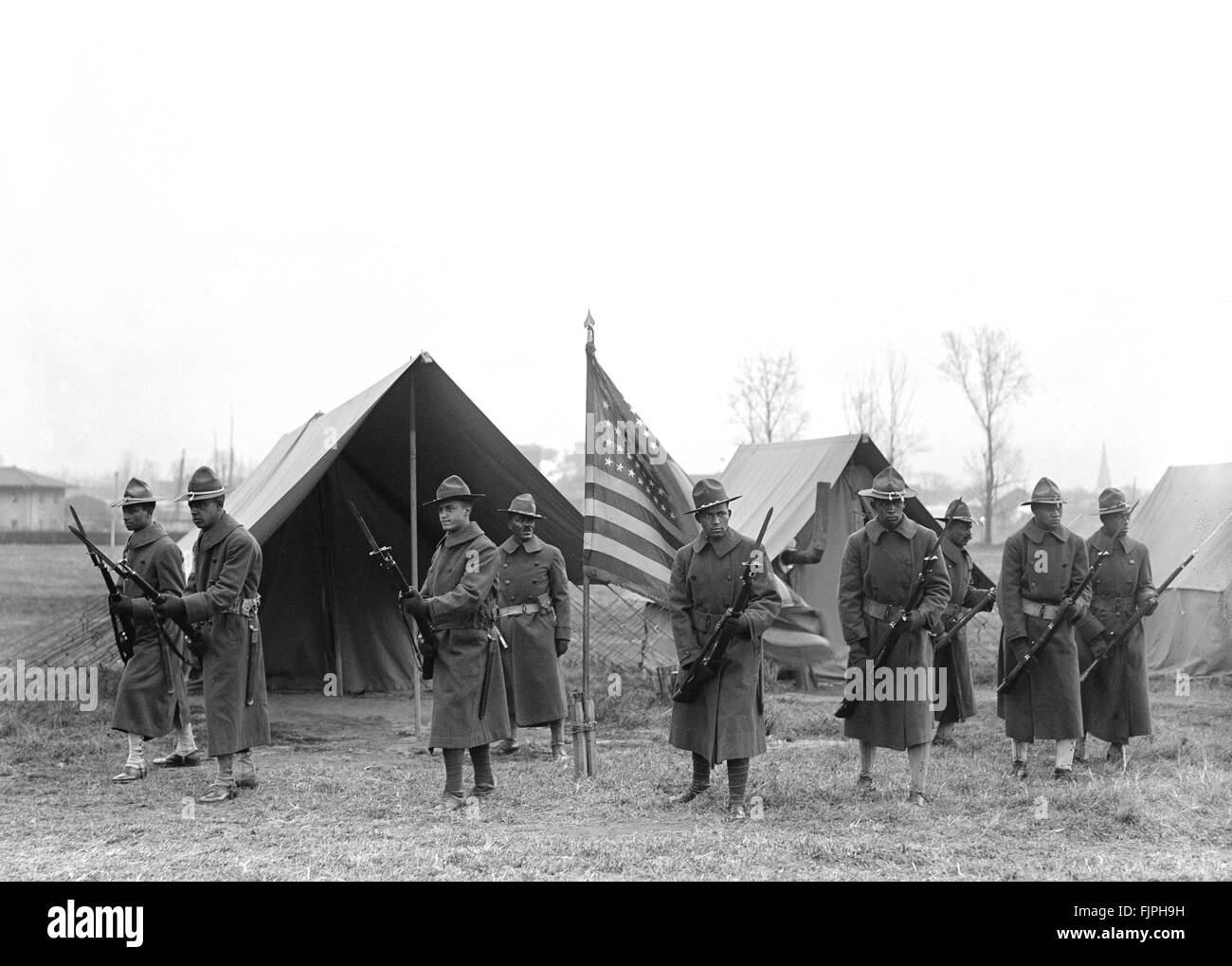 Soldats américains avec des baïonnettes apposées sur les fusils de protection des tentes de l'armée et drapeau américain, Harris & Ewing, 1917 Banque D'Images