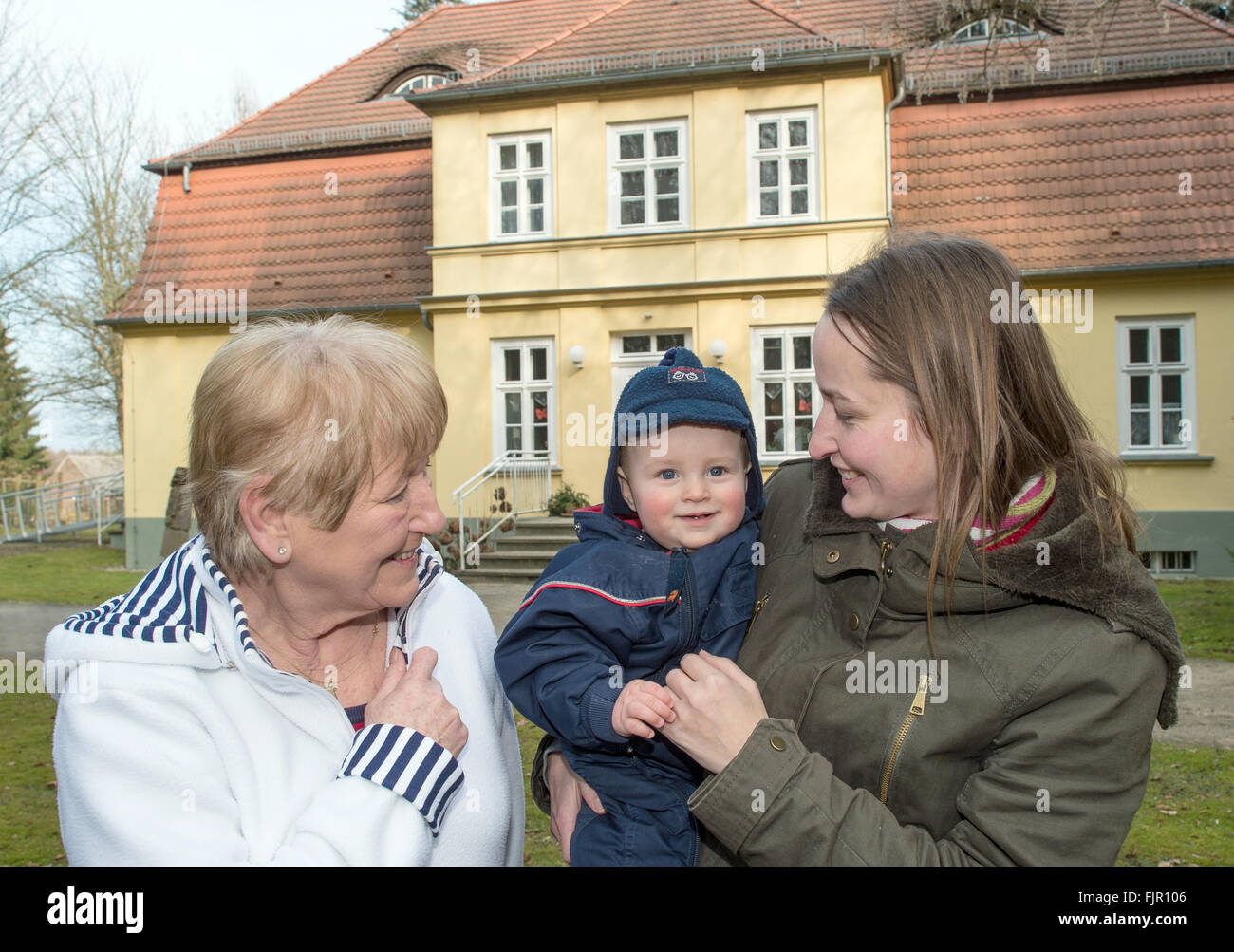 Kolpin, Allemagne. Feb 17, 2016. Inge Anders (L) parle à Sabine Seidel et son fils Moritz au motif de la multi-generation projet "Alte Foersterei" (lit. Ancien bureau du garde forestier) dans Kolpin, Allemagne, 17 février 2016. Le projet s'appuyant sur les locaux de l'ancienne académie judiciaire de Brandebourg a été lancé en 2009. Photo : PATRICK PLEUL/dpa/Alamy Live News Banque D'Images