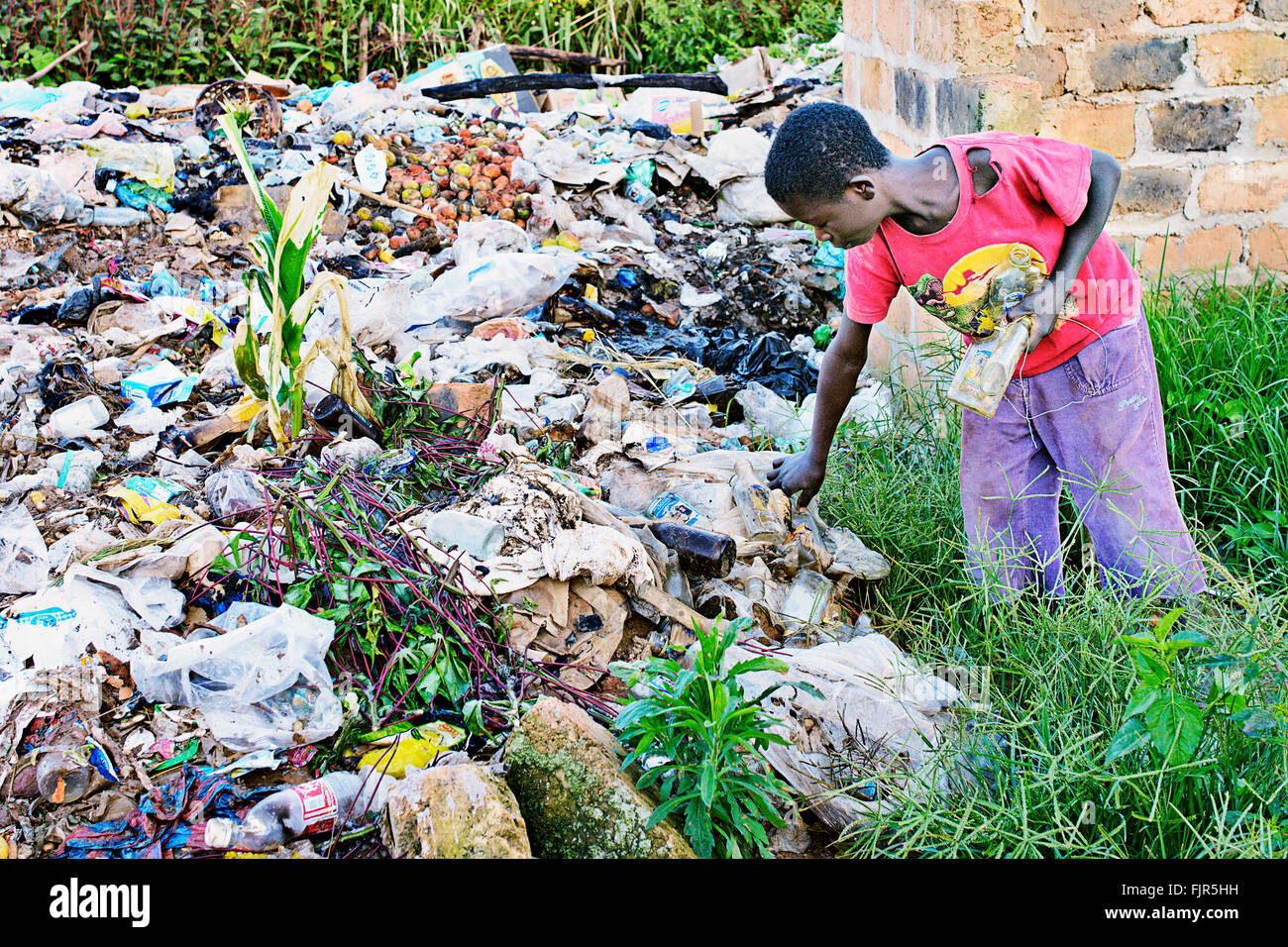 Petit garçon la collecte des ordures à un dépotoir à Manyama, Zambie. Banque D'Images