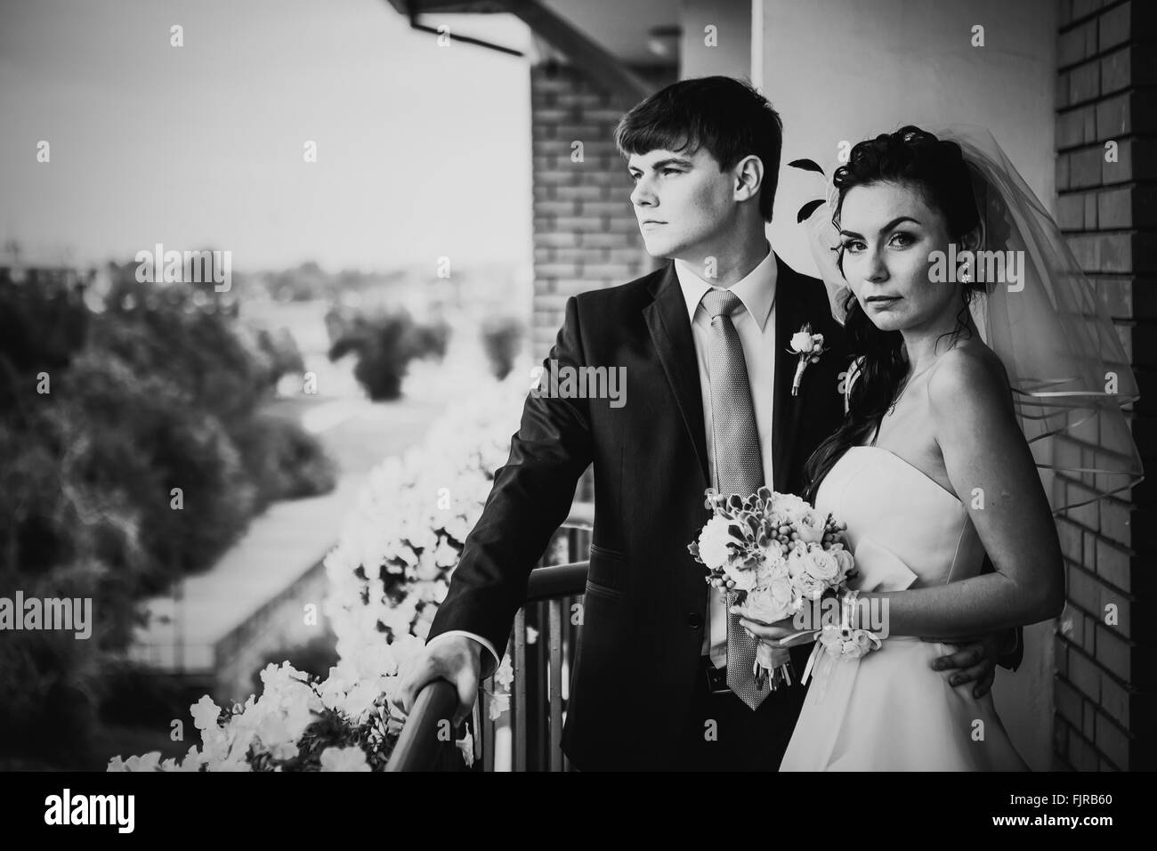 Photographie noir et blanc beau jeune couple debout sur le balcon Banque D'Images