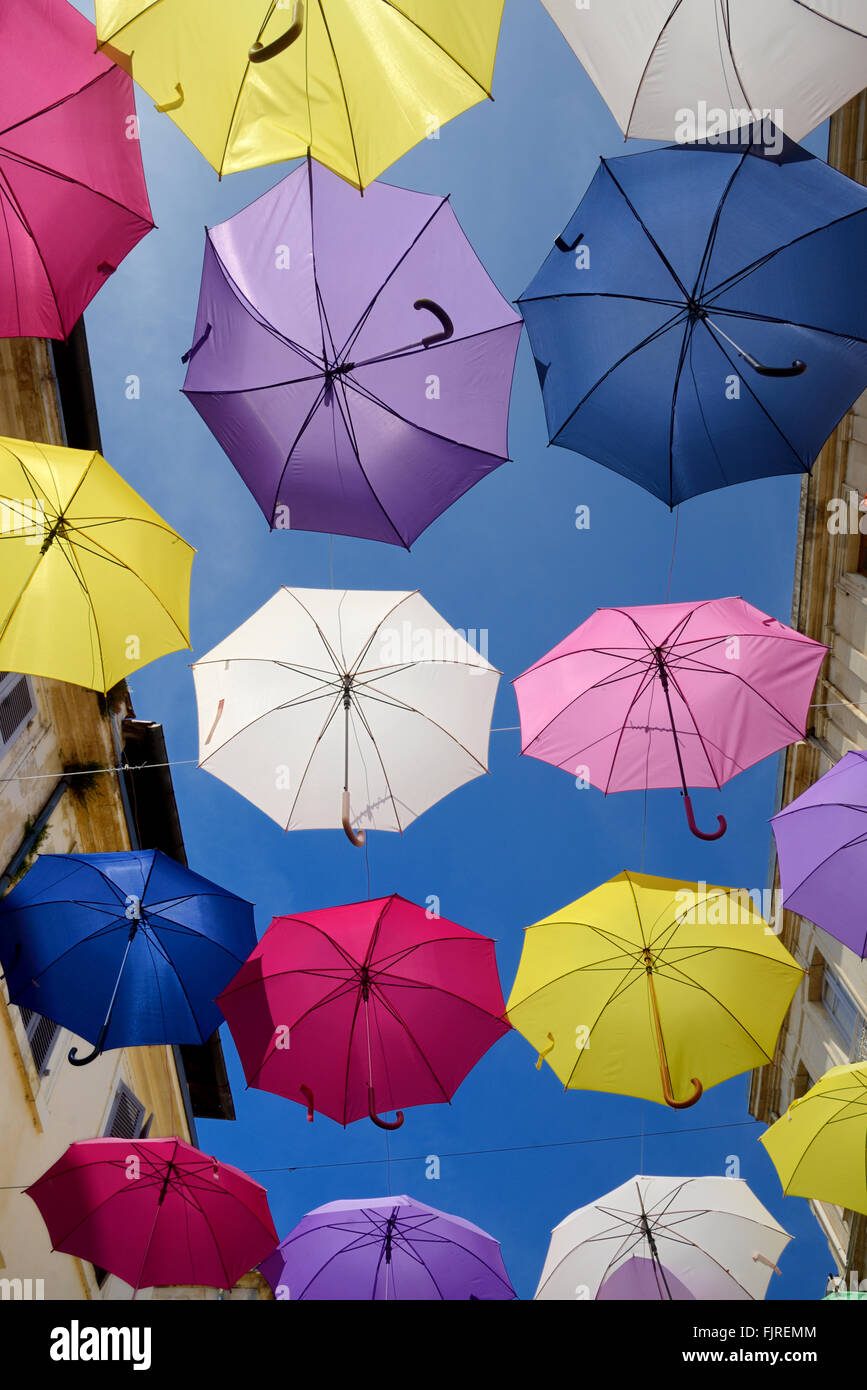 Affichage des parasols colorés Silhouetté contre le ciel bleu. Le Street Art ou art de l'installation dans les rues d'Arles, Provence, France Banque D'Images