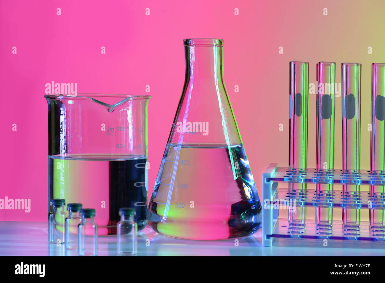 La verrerie de laboratoire de réflexion sur fond coloré sur la table Banque D'Images