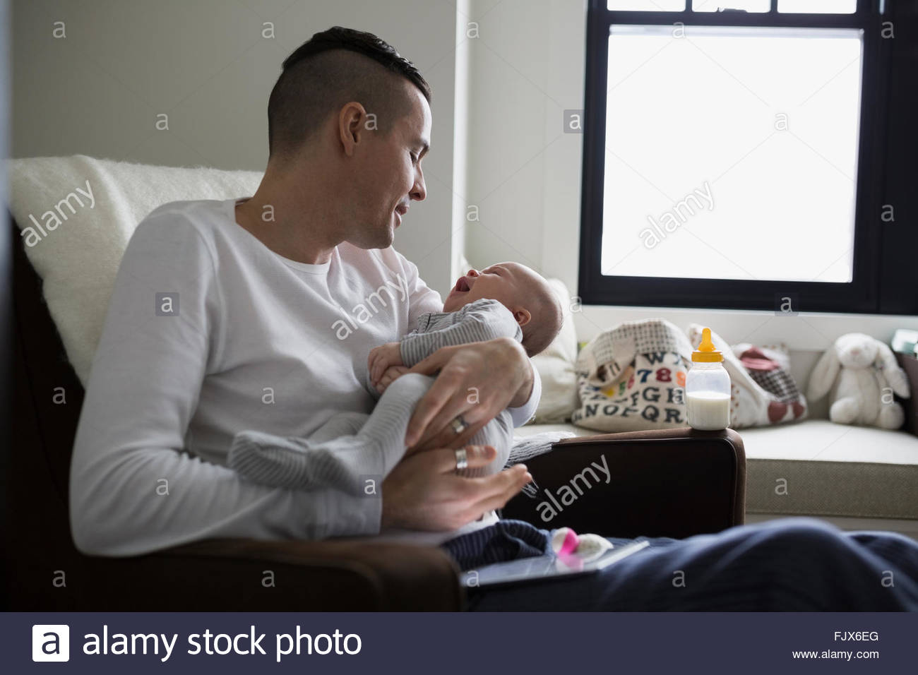 Père Fils holding baby in nursery Banque D'Images