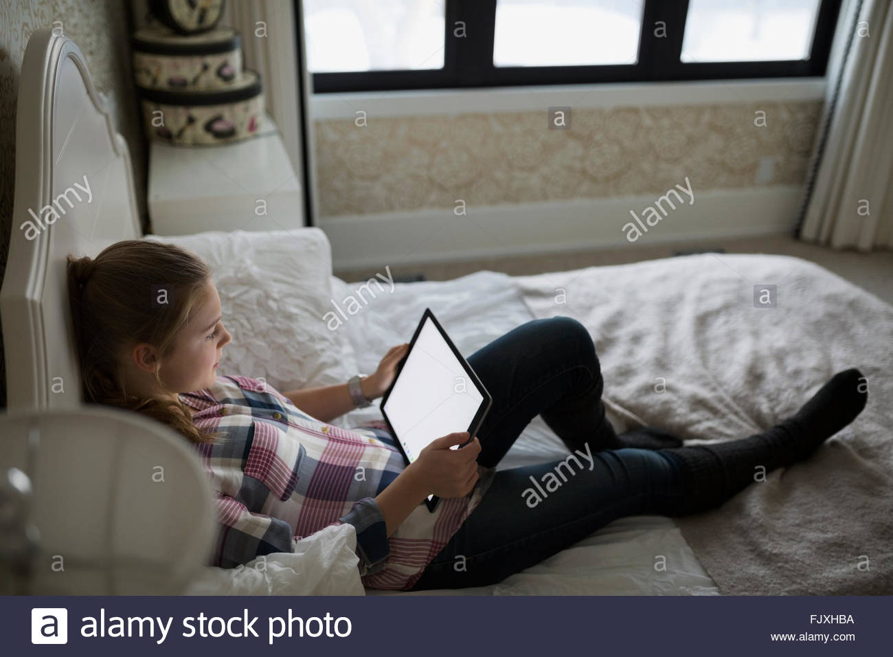 Teenage girl sitting on bed Banque D'Images