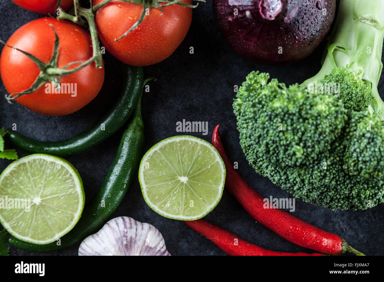 Hot Chili Peppers, Tomates, ail, oignon, citron vert, et le brocoli sur grunge background. Vue d'en haut. Banque D'Images