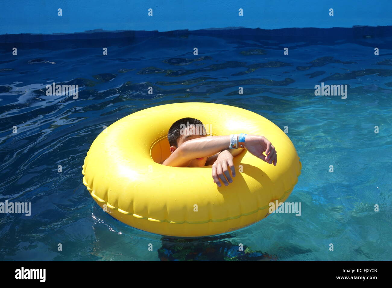 Jeune garçon asiatique flottant sur un tube d'eau Banque D'Images