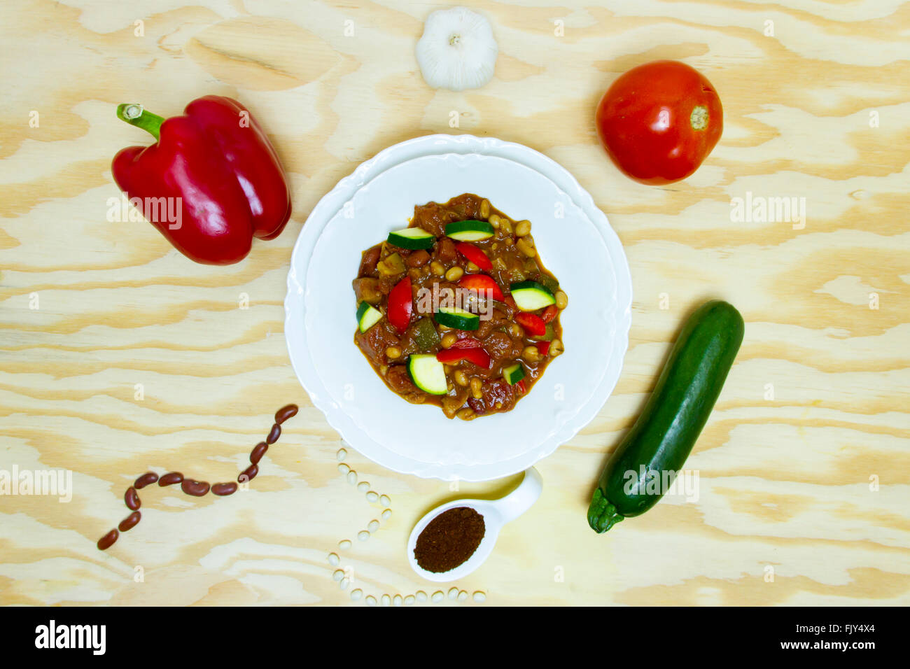 Composantes du chili aux légumes décomposé autour de bol sur la table. Banque D'Images