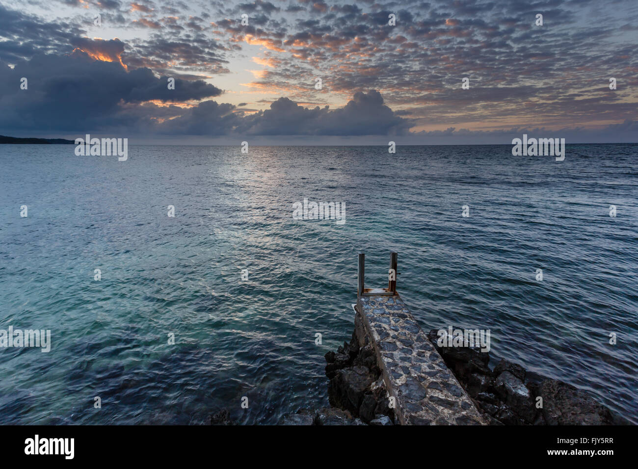 Beau coucher du soleil des Caraïbes en vue du petit rocky point sur les récifs coralliens Banque D'Images