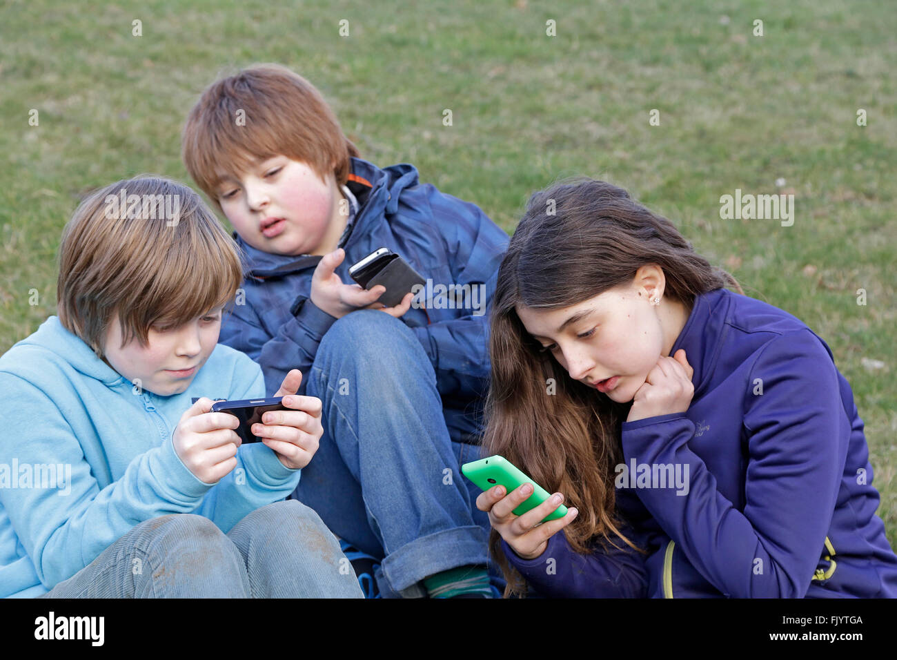 Enfants jouant avec leurs smartphones Banque D'Images